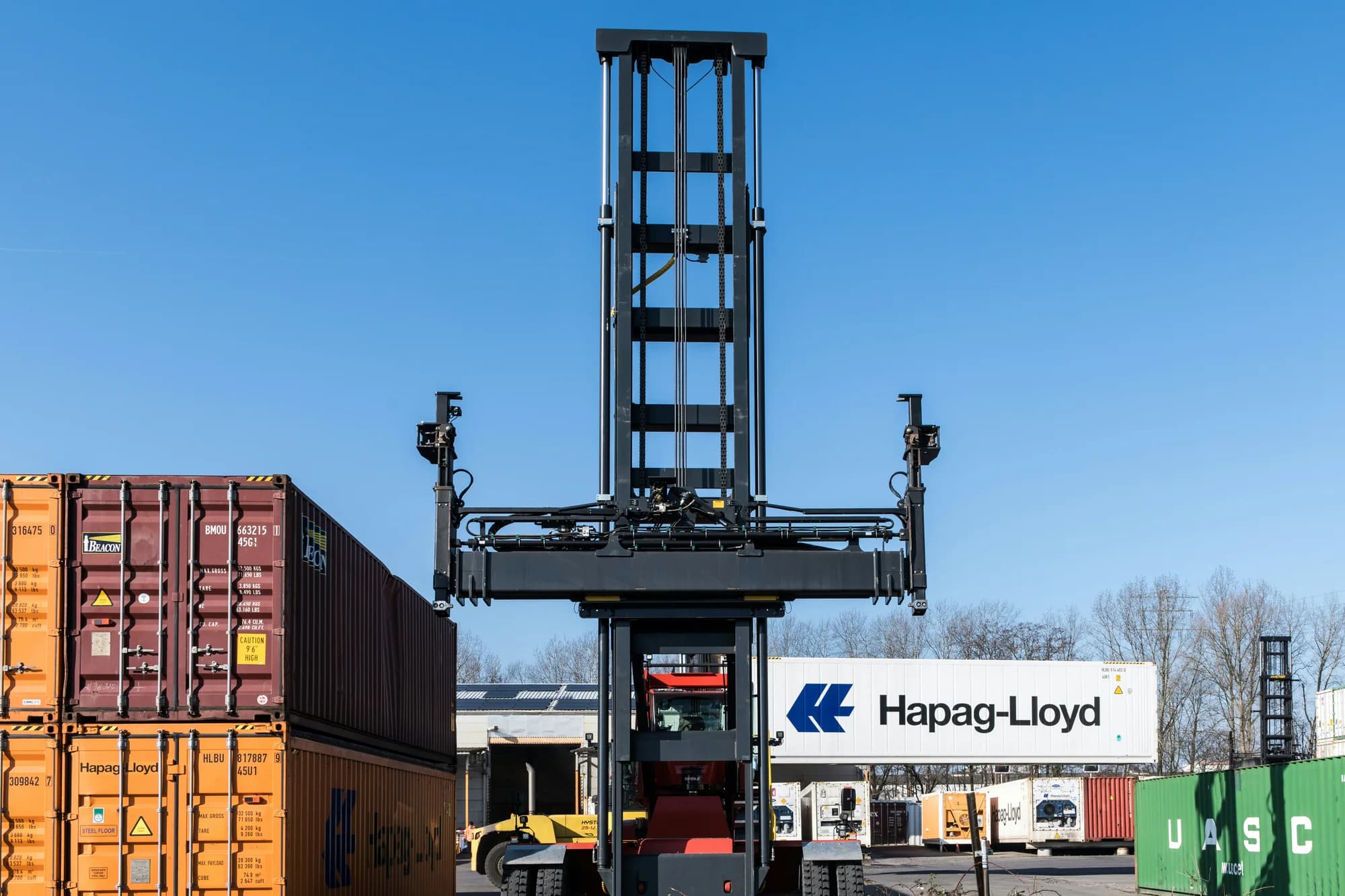 Container reach stacker handling shipping containers at a freight depot
